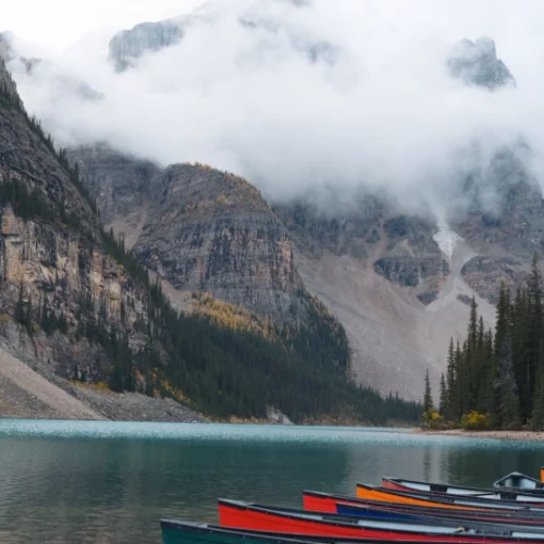 Row boats on mountain lake. Canadian Rocky Mountains with low hanging clouds.